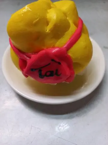 Hình ảnh Bánh bao hinh Túi tiền màu vàng có chữ  Tài  1 cái